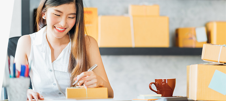 Small business owner writing package label for Skiesfreight shipping.