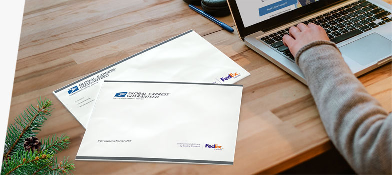 Person with laptop preparing to send two GXG envelopes for the holidays.
